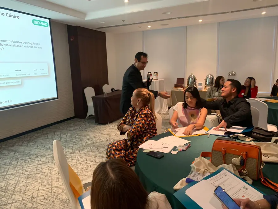Expositor presentando ante los asistentes en las mesas de trabajo