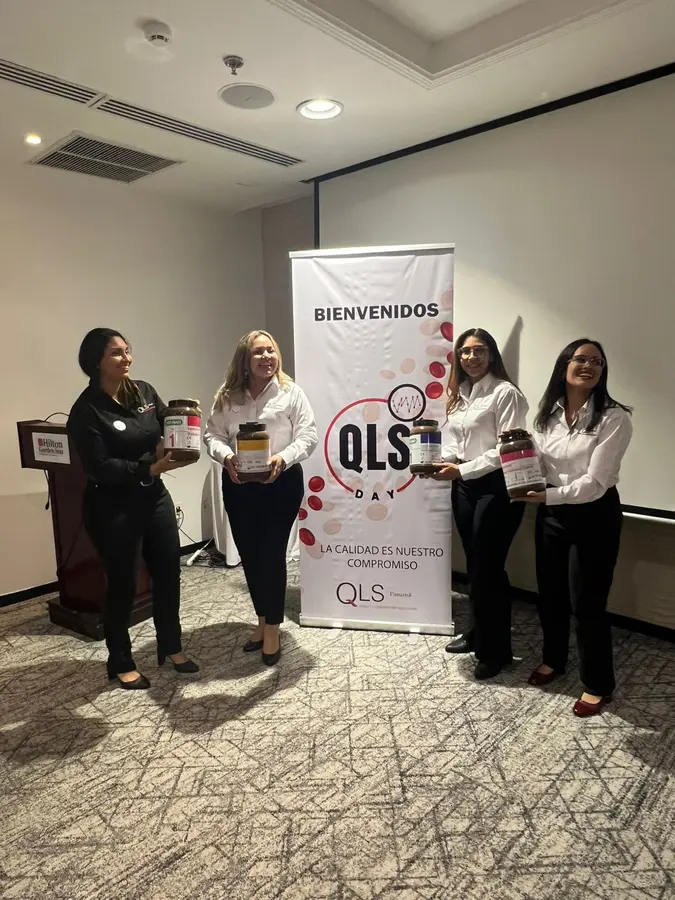 Asistentes con obsequios junto al banner del QLS Day
